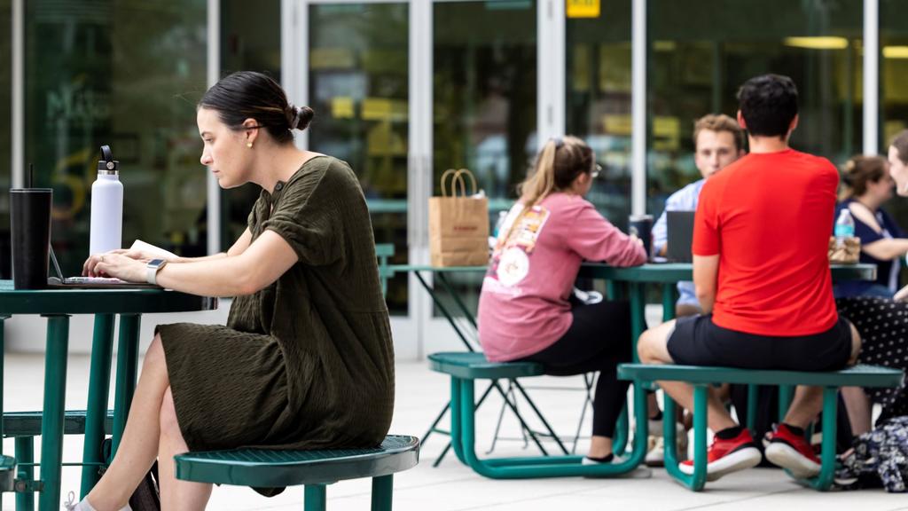 Students relax and eat around the Mason Square plaza.