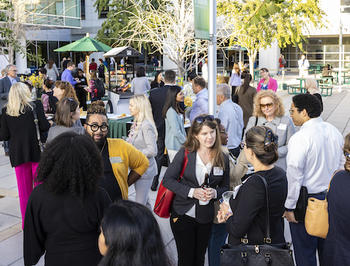 Attendees in business attire attend the Movers and Shakers event on the plaza.